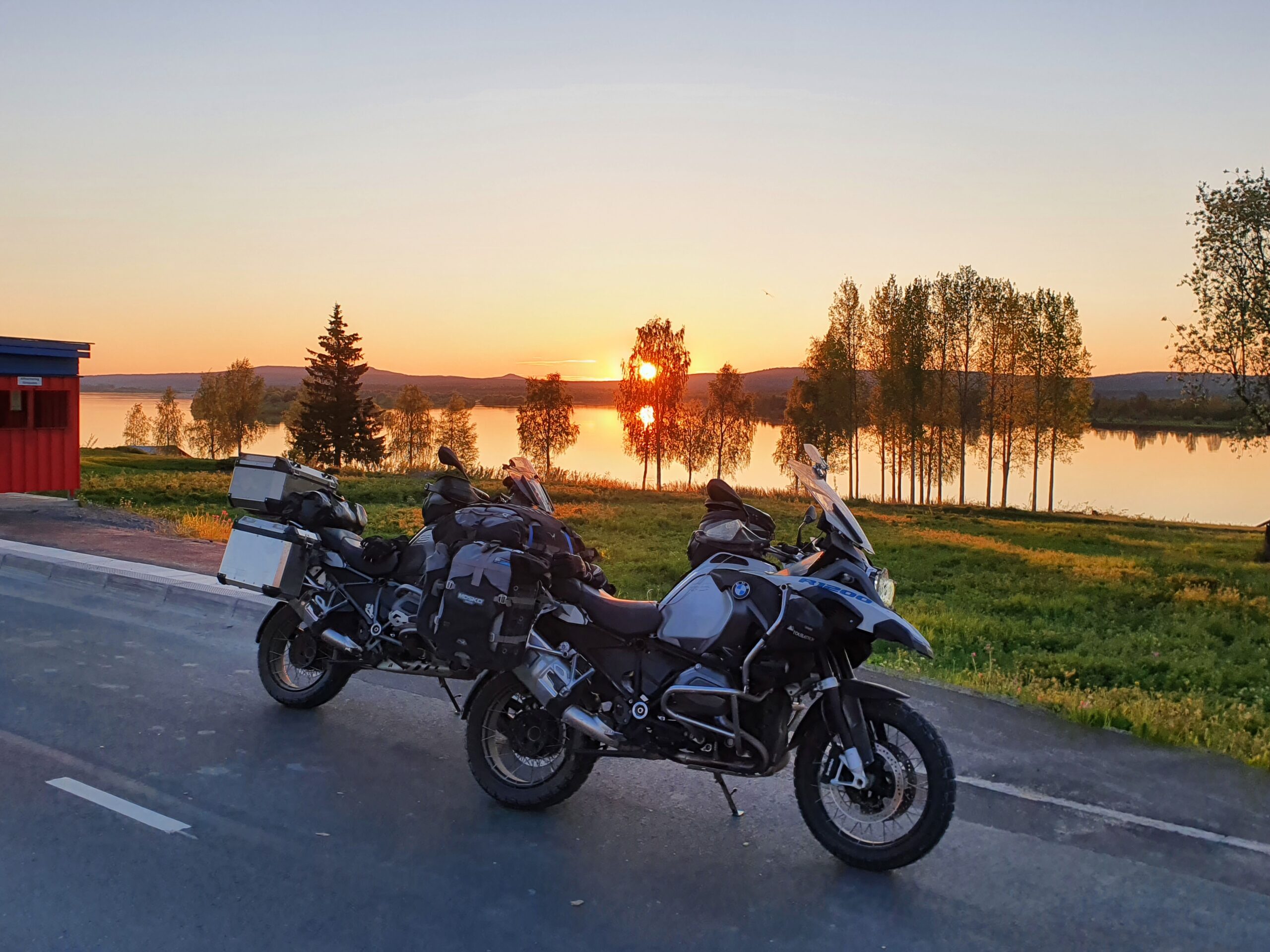 Parkerade motorcyklar i skymning vid vatten